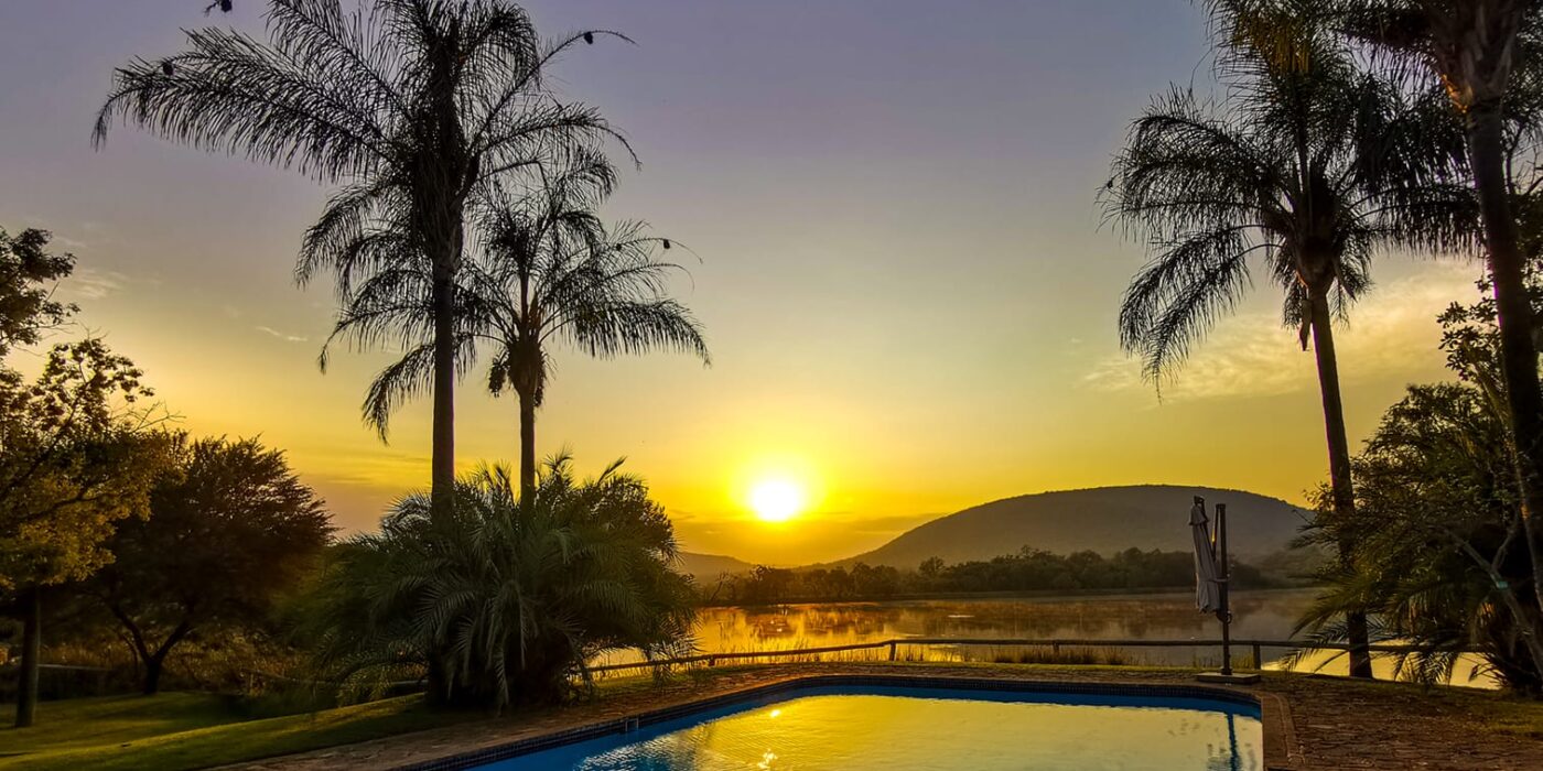 Hippo Lakes Safari lodge swimming pool with sunrise